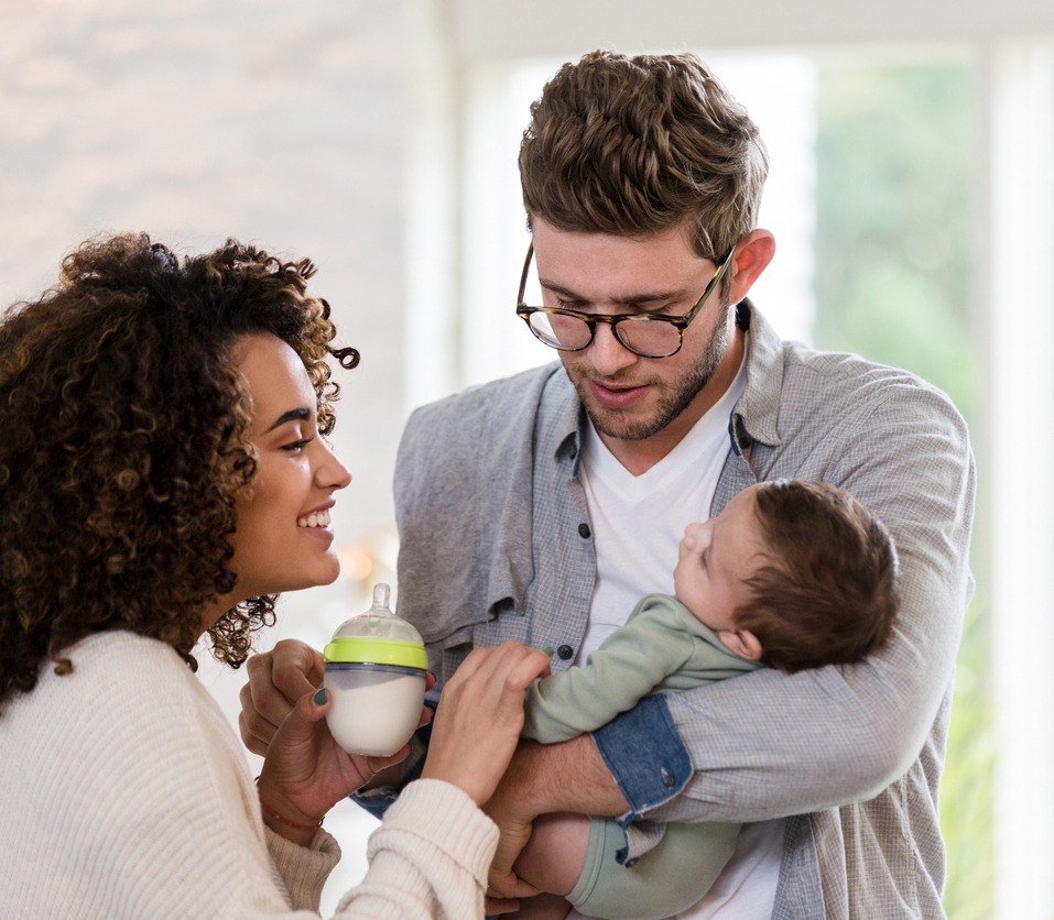 new parents with baby bottle